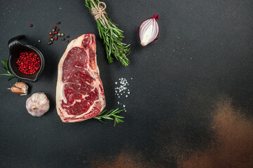 Wall Mural - Raw New York steak on a dark background. banner, menu, recipe place for text, top view