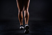 Shaped Female Legs In Sneakers Sculpted In Muscles, Dark Background
