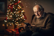 Solitude, loneliness during Christmas holidays. Eldery man sitting on sofa near decorated Christmas tree at home. Lonely senior man celebrating Christmas alone, looking to smartphone screen