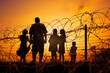 © the_lightwriter - refugees in front of barbed wire border