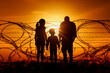 © the_lightwriter - refugees in front of barbed wire border