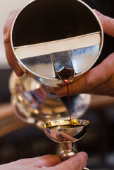 Wall Mural - Altar wine poured into an altar silver cup by the priest