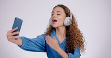 Woman, Peace Or Headphones For Selfie In Studio, Live Streaming Or Video Call On White Background. Profile Picture, Happy Gen Z Model And V Sign With Tongue Out, Blowing Kiss Or Emoji On Social Media