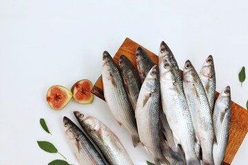 Wall Mural - Mullet fish, seafood, on a white background, on the kitchen table, healthy eating, top view, place for text, free space, background for presentations