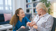 © Synthex - A young nurse visits a senior lady in a nursing home, inquiring about her well-being