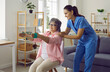 © Studio Romantic - Elderly active woman exercising with blue elastic band. Attentive female physiotherapist or personal trainer assisting cheerful senior woman in rehab. Active lifestyle, care, support of elderly people