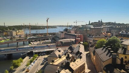 Sticker - Aerial view of rooftops of houses and a train railway on a river in Stockholm, Sweden