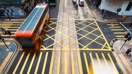 Wall Mural - Timelapse of Asian people walk cross zebra crossing, car bus traffic transport on road junction in Hong Kong Central city downtown. Pedestrian commuter lifestyle, Asia city life, public transportation