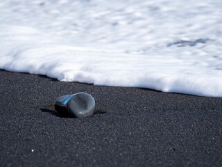 Poster - Stunning vista of a black sand beach adorned with rolling blue ocean waves