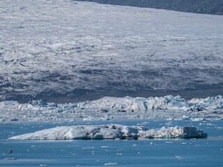 Sticker - Picturesque landscape of an iceberg in the water with a backdrop of snow-covered mountains