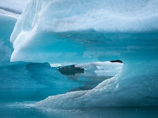 Sticker - Picturesque landscape of an iceberg in the water with a backdrop of snow-covered mountains