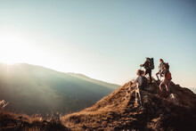 Young And Diverse Group Of Female Friends Hiking And Looking At The Sun Rising Behind A Nearby Hill