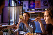 © Marko Geber - Diverse group of young people eating sushi and using a smart phone in a sushi restaurant
