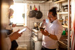 © Marko Geber - Young male sushi chefs using their smart phones in the morning before their shift starts at a sushi restaurant