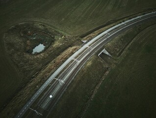 Poster - two railroad tracks and a pond in the middle of a field