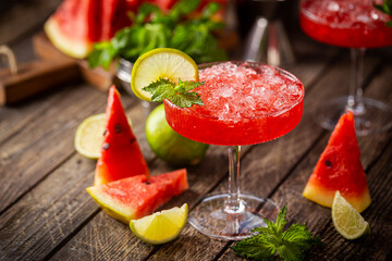 Watermelon frozen cocktail margarita with fresh watermelon, lime and mint on wooden background