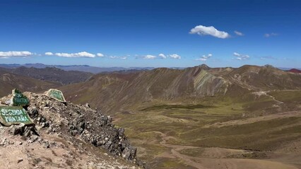 Poster - Beautiful view of a group of people hiking in dry volcanic landscapes under the blue sky