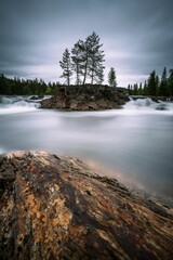 Sticker - an island surrounded by trees and water is surrounded by a large rock