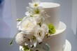 White three-tier wedding cake adorned with white flowers
