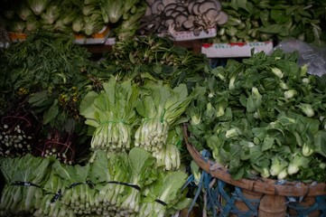 Wall Mural - Vibrant display of fresh vegetables is presented on a wooden table at a local market