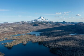 Sticker - Areal view of a tranquil glacial lake surrounded by snow-capped mountains in the background