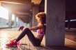 © Geber86 - Young woman resting after jogging and exercising in a parking lot