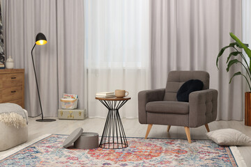 Canvas Print - Stylish gray armchair and small table in living room. Interior design