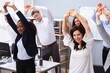 Young Businesspeople Doing Stretching Exercise At Workplace