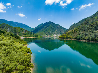 Wall Mural - Aerial photography of a large reservoir with blue sky and white clouds and mountains