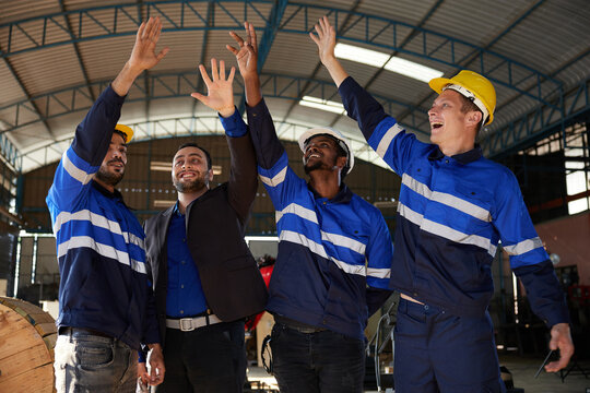 workers and businessman raised hands in celebration form finish work or project in the factory