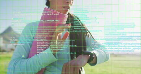Animation of computer language and grid pattern, biracial woman using smartwatch