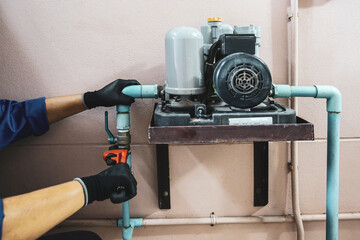 Wall Mural - Technician plumber using a wrench to repair a water pump pipe. Concept of maintenance, fix water plumbing leaks drop or house bathroom service or cleaning clogged pipes is dirty or rusty.