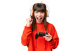 Little caucasian girl playing with a video game controller over isolated background celebrating a victory in winner position