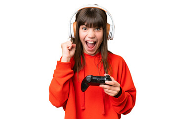 Wall Mural - Little caucasian girl playing with a video game controller over isolated background celebrating a victory in winner position