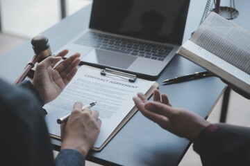 Business and lawyers discussing contract papers with brass scale on desk in office. Law, legal services, advice, justice and law concept picture with film grain effect