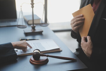 Business and lawyers discussing contract papers with brass scale on desk in office. Law, legal services, advice, justice and law concept picture with film grain effect