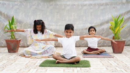 Kids relaxing and exercising, Little children practicing yoga indoors..