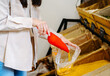 © dvulikaia - Young woman collects lentils in  plastic bag at  local market.