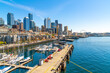 Panoramic view of the Seattle Waterfront along the Puget Sound with downtown district skyscrapers, the Pike Place Market district, and Great Wheel in view from the harbor in Seattle Washington, USA.	