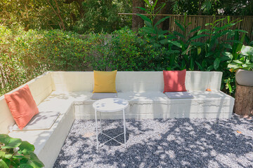 white wooden bench in the garden with beautiful green plants background.