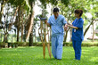 © KL 1981 - Asian Female Doctor Help Support Senior Patient and Provide Encouragement During Treatment. Rehabilitation or Physical Therapy of Asian Retired Patients with Crutches Wooden.
