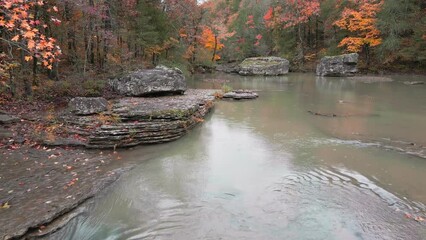 Wall Mural - Multiple waterfalls flow over rock cascade in the Arkansas mountains during autumn with fall colored forest tree leaves  