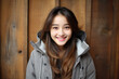 © Anastasiia - Happiness Asian Girl In Gray Jacket On Wooden Plank Background