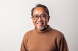 © Anne-Marie Albrecht - Medium shot portrait of a Indonesian man in his 50s in a white background wearing a cozy sweater