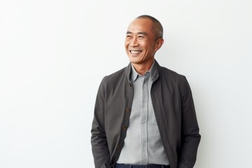 Wall Mural - Portrait of a happy mature asian man smiling against white background