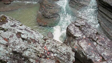 Wall Mural - Birds Eye view of multiple waterfalls flowing over rock cascade in the mountains during autumn with fall colored forest tree leaves    