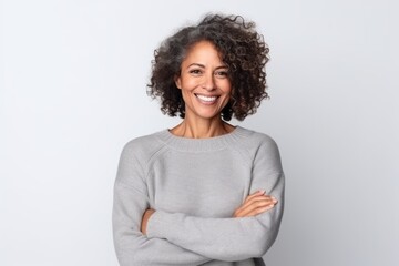 Wall Mural - Medium shot portrait of a Brazilian woman in her 40s in a white background wearing a cozy sweater