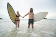 © FotoArtist - Happy couple surfing together on beach with surfing board in Pattaya, Thailand.