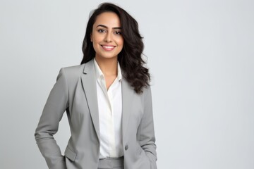 Wall Mural - Portrait of a smiling businesswoman standing with hands on hips against white background