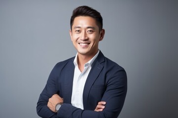 Wall Mural - Medium shot portrait of a Chinese man in his 30s in a minimalist or empty room background wearing a chic cardigan